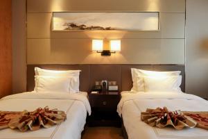 Postel nebo postele na pokoji v ubytování Tianhong Jinling Grand Hotel