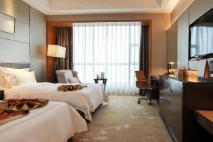 Postel nebo postele na pokoji v ubytování Tianhong Jinling Grand Hotel