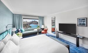 a hotel room with a couch and a television at InterContinental Sydney, an IHG Hotel in Sydney