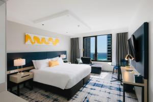 a hotel room with a bed and a tv at voco Gold Coast, an IHG Hotel in Gold Coast