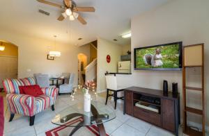 a living room with a flat screen tv on a wall at Relaxing resort, spacious pool near Disney in Davenport