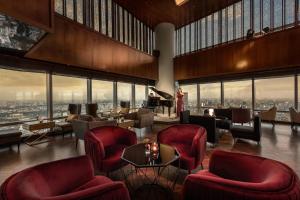 a hotel lobby with red chairs and a piano at Lotte Hotel Hanoi in Hanoi