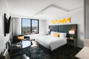 Habitación de hotel con cama, escritorio y silla en voco Gold Coast, an IHG Hotel, en Gold Coast