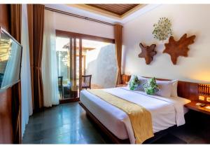 Un dormitorio con una gran cama blanca y una ventana en The Canggu Boutique Villas & Spa by ecommerceloka, en Canggu