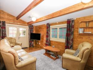 a living room with two chairs and a table at The Log Cabin in Swindon