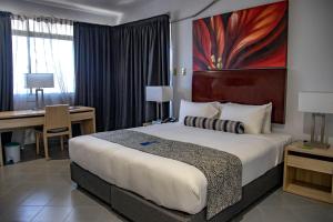 a hotel room with a large bed and a desk at Bird Of Paradise Hotel in Goroka