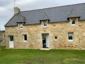 a large stone building with a black roof at Maison TY Traon - in Audierne