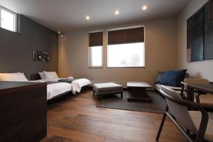 a hotel room with two beds and a couch at Orchid Furano in Furano