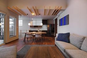 a living room with a couch and a table at Orchid Furano in Furano