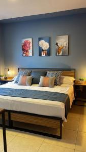 グアダラハラにあるCASA Azul Turquesa Excelente Ubicacion Facturamosの壁に絵画が飾られたベッドルームの大型ベッド1台