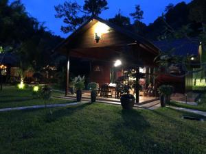 a pavilion with a table in a yard at night at Kemuning Orchard Villaa in Kerling