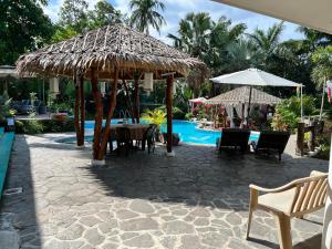 patio con tavolo, ombrellone e piscina di AWILIHAN PRIVATE PARADISE RESORT a Ambulong