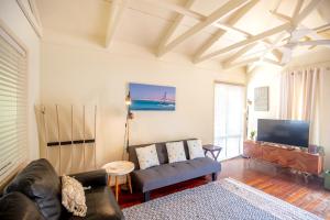 un salon avec un canapé et une télévision dans l'établissement THE DUNES + 100M TO BEACH + POOL + EXCEPTIONAL LOCATION, à Point Lookout