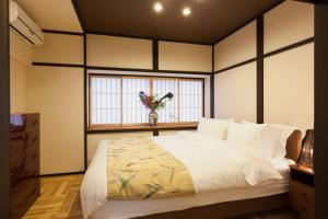 a bedroom with a large bed with a window at 香柏 西京極 - Kouhaku Nishikyogoku, Kyoto Machiya in Kyoto