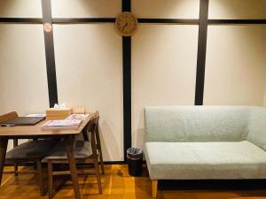 a room with a table and a chair and a clock at 香柏 西京極 - Kouhaku Nishikyogoku, Kyoto Machiya in Kyoto