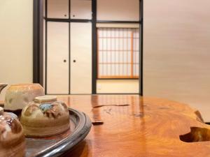 a table with a vase on a table with a door at 香柏 西京極 - Kouhaku Nishikyogoku, Kyoto Machiya in Kyoto