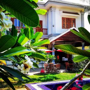 una casa con plantas verdes delante de ella en Villa b.Maison d'Hôtes Angkor en Siem Reap