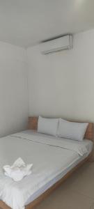 a bed with white sheets and pillows in a room at Sweet Time Bungalows in Koh Rong Sanloem