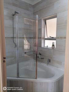 een badkamer met een bad en een douche bij DuneSide Guest House in Richards Bay
