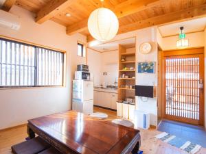a kitchen with a wooden table in a room at Guest House Wakabaya in Takamatsu