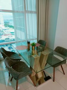 a glass table and chairs in a room with a view at (Cutiepie)Duplex condo@Maritime 8 in George Town
