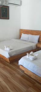 two twin beds in a room with wooden floors at Sweet Time Bungalows in Koh Rong Sanloem