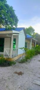 a house with a tree branch in front of it at Sweet Time Bungalows in Koh Rong Sanloem