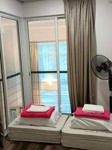 two beds in a room with a large window at (Cutiepie)Duplex condo@Maritime 8 in George Town