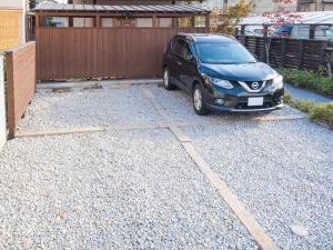 a black car parked in a gravel driveway at Guest House Wakabaya in Takamatsu +27 photos