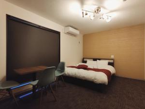 a bedroom with a bed and a table and chairs at West Japan Kyoto Kiyomizu in Kyoto
