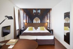 um quarto com uma cama grande e uma secretária em Sorell Hotel Rütli em Zürich