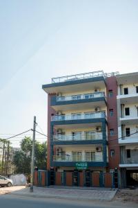 um edifício de apartamentos alto ao lado de uma rua em The Palms Inn em Gurgaon