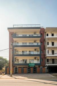 um edifício de apartamentos alto com uma placa em frente em The Palms Inn em Gurgaon