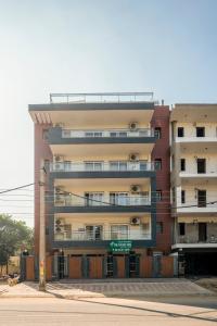 een hoog appartementencomplex met een bord ervoor bij The Palms Inn in Gurgaon