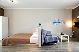 a bedroom with a bed and a chair at Maria's modern studio 5min from beach in Souda