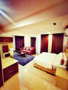 a bedroom with a bed and a living room at Diamond Star Hotel فندق النجمة الماسية in Seeb