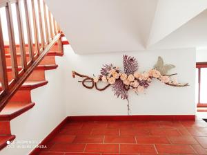 a wreath on the wall of a staircase with flowers at Mini hotel in Quincinetto