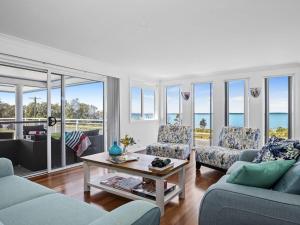 a living room with two couches and a table at Bay Views in Callala Bay