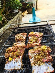 a grill with four pieces of meat on it at Homstay Sinh thái Cây Sung Mộc Châu in Mộc Châu