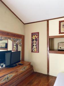 a living room with a tv and a window at Sapulidi Cafe, Gallery & Resort in Lembang