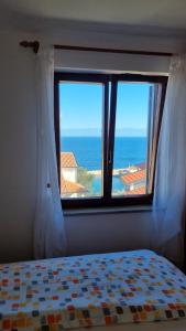 una camera da letto con finestra affacciata sull'oceano di Apartments Katja a Mali Lošinj (Lussinpiccolo)