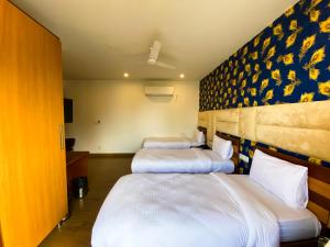 two beds in a hotel room with a wall at Sky Suites in Gurgaon
