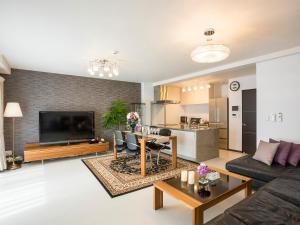 a living room with a couch and a tv at Kyoto Four Sisters Residence in Kyoto