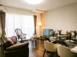 a living room with a couch and a dining room at Kyoto Four Sisters Residence in Kyoto