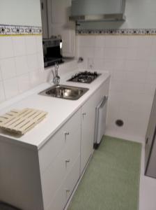 a white kitchen with a sink and a stove at Quinta dos Campos - Apartamento 1 in Braga