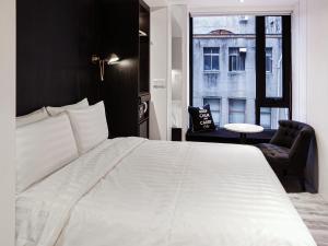 a bedroom with a large white bed and a window at Hotel Relax III in Taipei