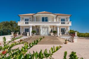 a large white house with stairs and plants at Frido Luxury Villa with Jacuzzi in Akrotiri