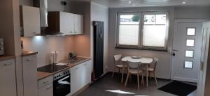 een keuken met een tafel en een kleine keuken met een aanrecht bij Luxus-Appartement II in Übach-Palenberg