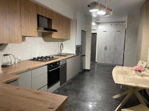 cocina con armarios de madera, mesa y encimera en Resident Hall, en Leópolis