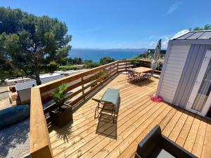 una terrazza in legno con tavolo e sedie. di Mobilhome 6 places vue mer a Drammont